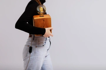 Figurantka, která drží v popdaží produkt značky REZ design s názvem Stoleté světlo.